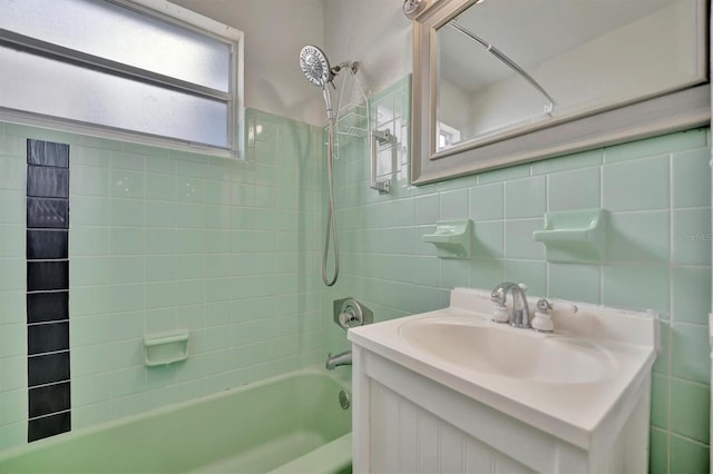 bathroom with tiled shower / bath combo, vanity, tile walls, and backsplash