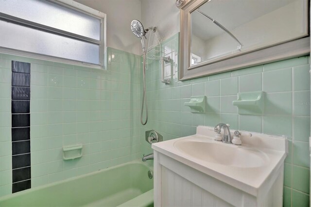 bathroom featuring vanity, tile walls, and shower / bathtub combination