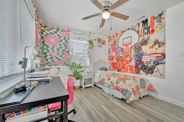 bedroom featuring ceiling fan, visible vents, baseboards, and wood finished floors
