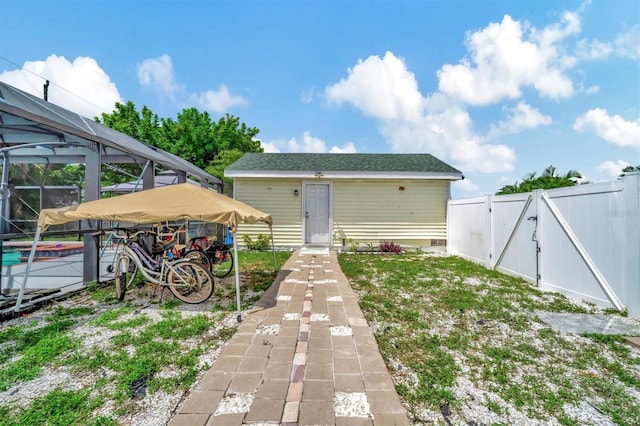 rear view of house featuring a fenced in pool, fence, a lanai, and a gate