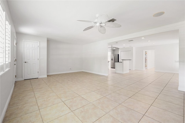 tiled empty room featuring ceiling fan