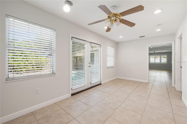 tiled empty room with french doors, a wealth of natural light, and ceiling fan