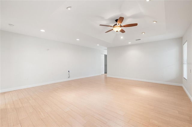 empty room with ceiling fan and light hardwood / wood-style floors