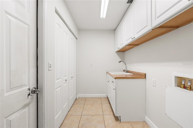 laundry area with washer hookup, light tile patterned floors, cabinets, and sink