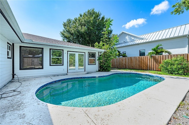 view of swimming pool featuring french doors and a patio area