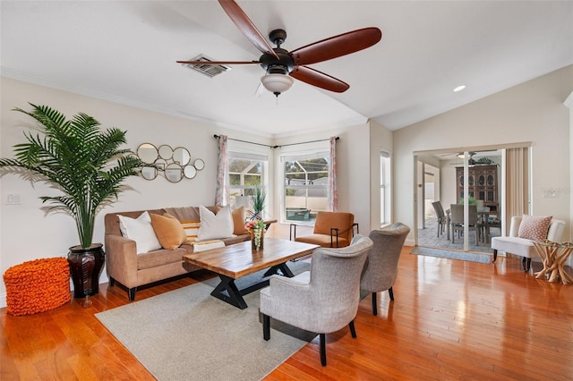 living room featuring light wood finished floors, visible vents, and ceiling fan