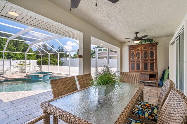 view of patio with glass enclosure, ceiling fan, and a pool with hot tub