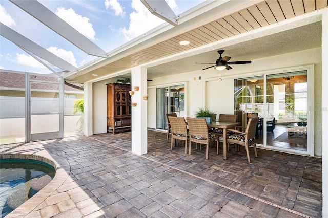 view of patio with outdoor dining space, a lanai, and ceiling fan