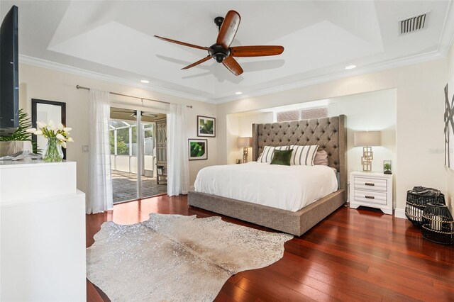 bedroom with crown molding, access to outside, ceiling fan, a tray ceiling, and dark wood-type flooring