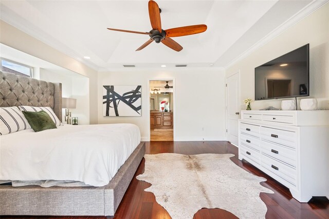 bedroom with dark wood-type flooring, a tray ceiling, ceiling fan, and ornamental molding