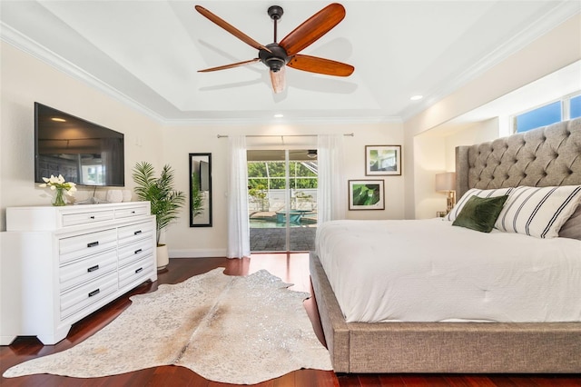 bedroom featuring dark wood-type flooring, ornamental molding, a ceiling fan, a tray ceiling, and access to exterior