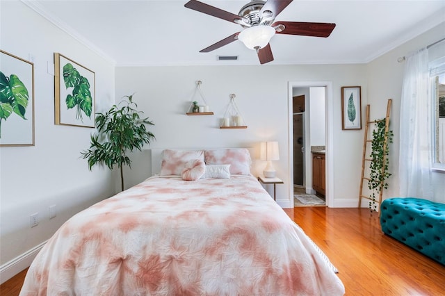 bedroom with ensuite bath, crown molding, hardwood / wood-style floors, and ceiling fan