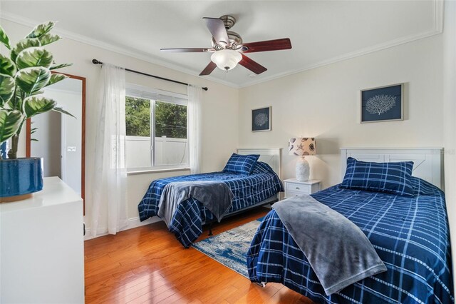 bedroom featuring crown molding, ceiling fan, and hardwood / wood-style floors