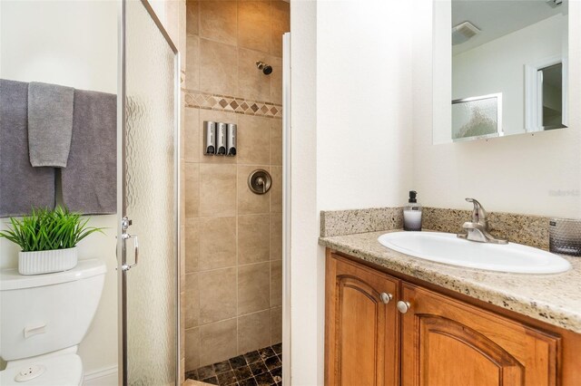 bathroom featuring vanity, toilet, and a shower with door