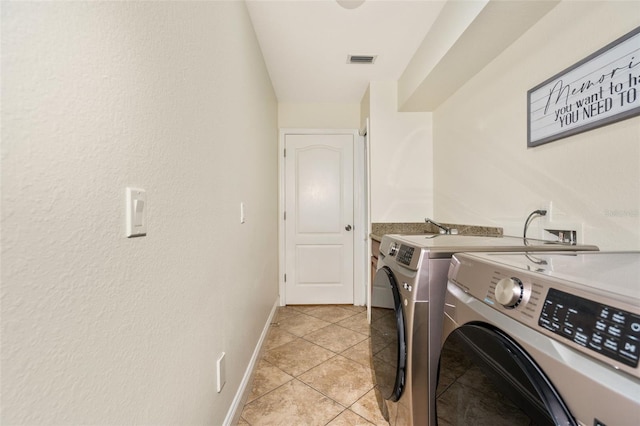 laundry area featuring visible vents, light tile patterned floors, baseboards, laundry area, and washing machine and clothes dryer