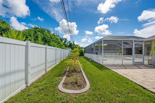 view of yard featuring glass enclosure, a patio, and fence