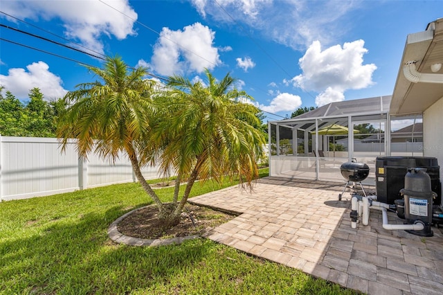 view of yard with glass enclosure, central AC, and a patio