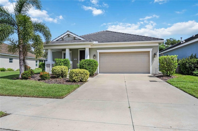 view of front of home featuring a garage, concrete driveway, a front yard, and stucco siding