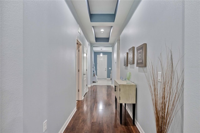 hall with hardwood / wood-style flooring and a tray ceiling