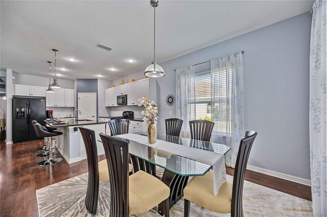 dining space with sink and hardwood / wood-style floors