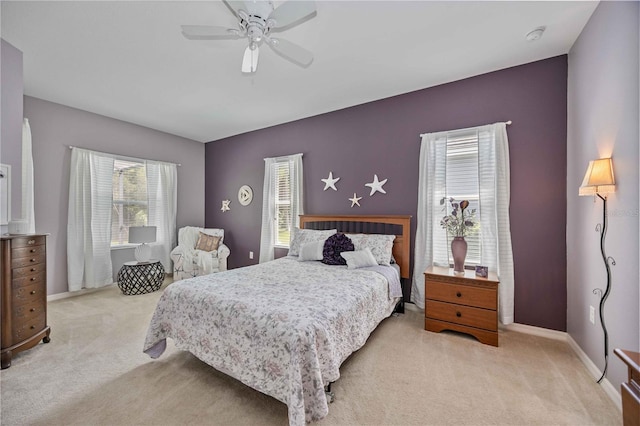 carpeted bedroom with ceiling fan and multiple windows