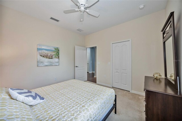 carpeted bedroom featuring ceiling fan and a closet