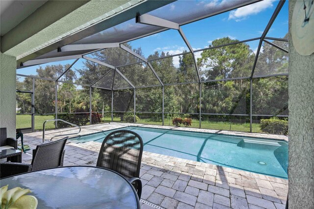 view of swimming pool with glass enclosure and a patio