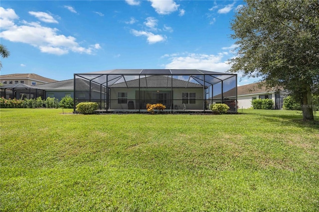 back of house featuring a lanai and a yard