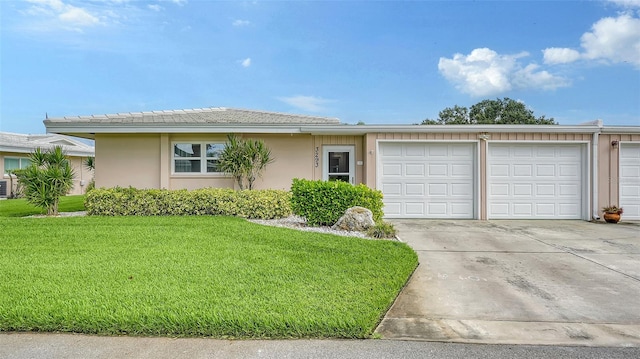 single story home featuring a front lawn and a garage