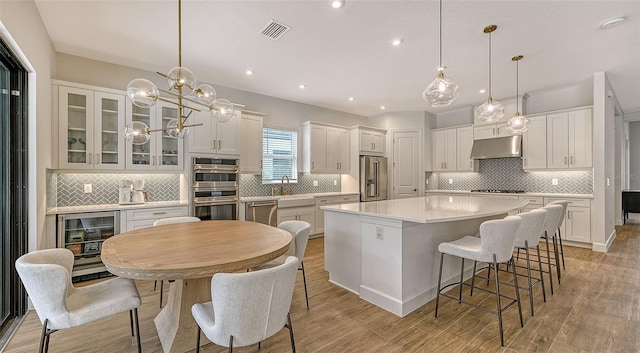 kitchen featuring white cabinetry, a kitchen island, stainless steel appliances, and light hardwood / wood-style floors