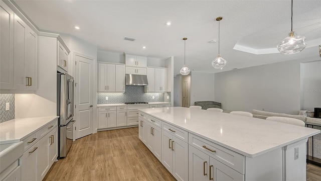 kitchen with white cabinets, appliances with stainless steel finishes, and light hardwood / wood-style flooring