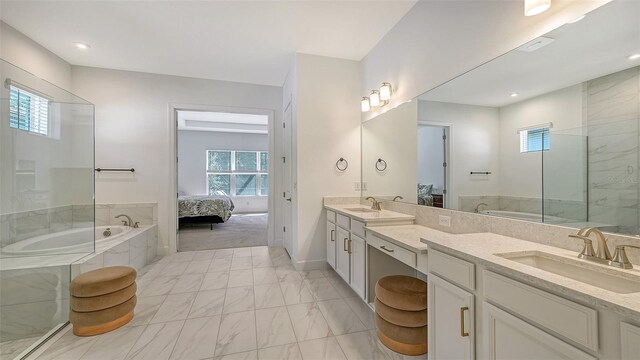 bathroom featuring vanity and a relaxing tiled tub