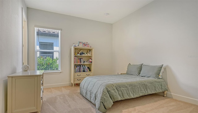 bedroom featuring lofted ceiling and light carpet