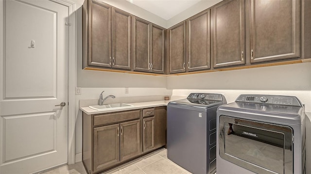 laundry room with cabinets, sink, light tile patterned flooring, and washing machine and dryer