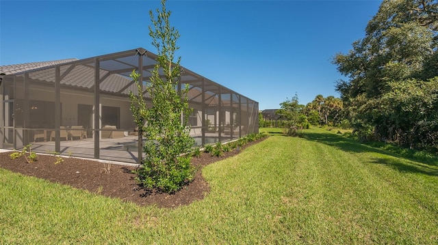 view of yard featuring glass enclosure and a patio