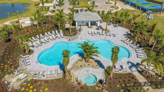 view of pool featuring a water view and a patio