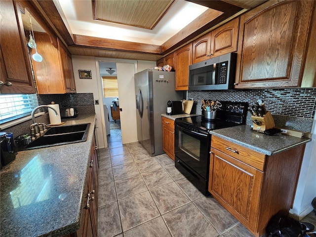 kitchen featuring a raised ceiling, decorative backsplash, sink, and stainless steel appliances