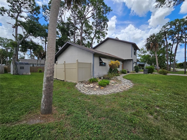 view of home's exterior featuring a lawn and a storage shed