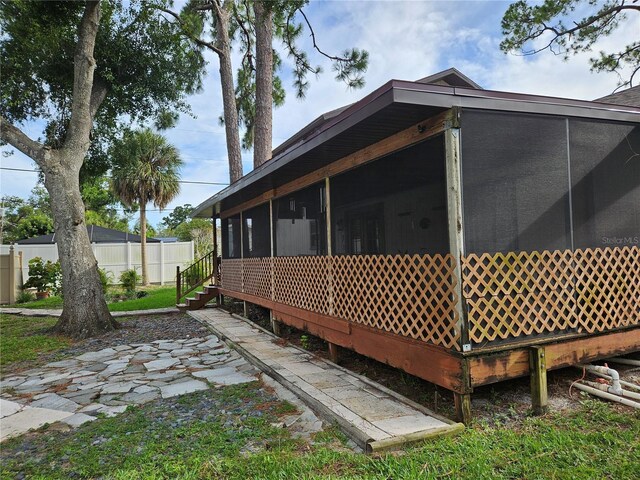 view of home's exterior with a sunroom and a patio area