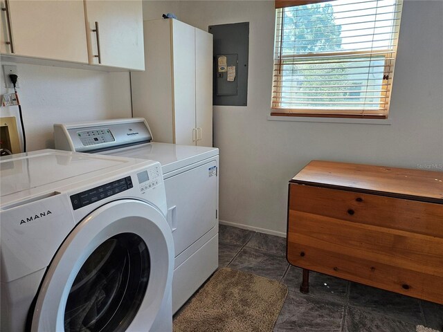 laundry room with electric panel, independent washer and dryer, cabinet space, and baseboards