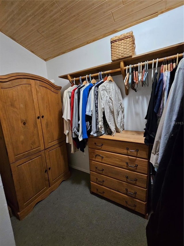 walk in closet featuring dark colored carpet