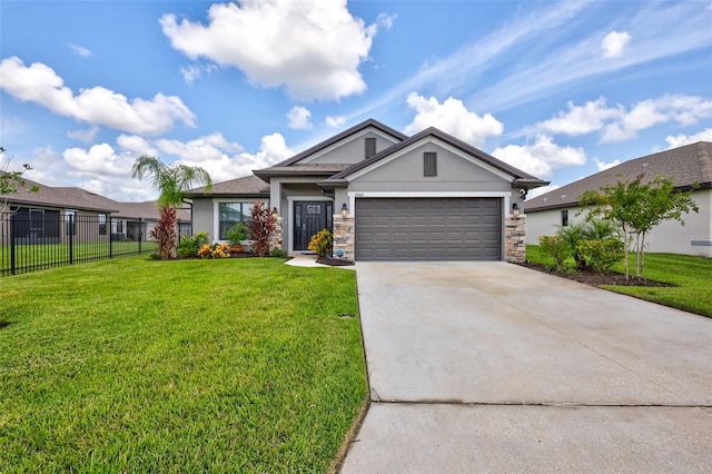 view of front facade with fence, a front yard, stucco siding, a garage, and driveway