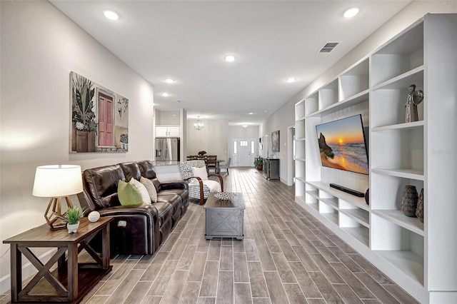 living room featuring wood-type flooring and built in shelves