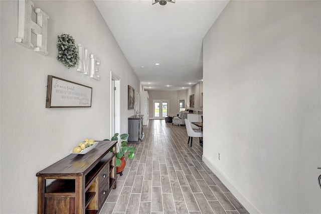 hall with baseboards and wood finish floors