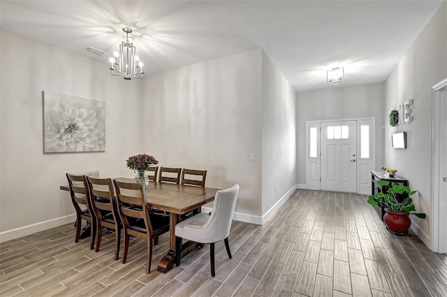 dining room featuring visible vents, baseboards, a chandelier, and wood tiled floor