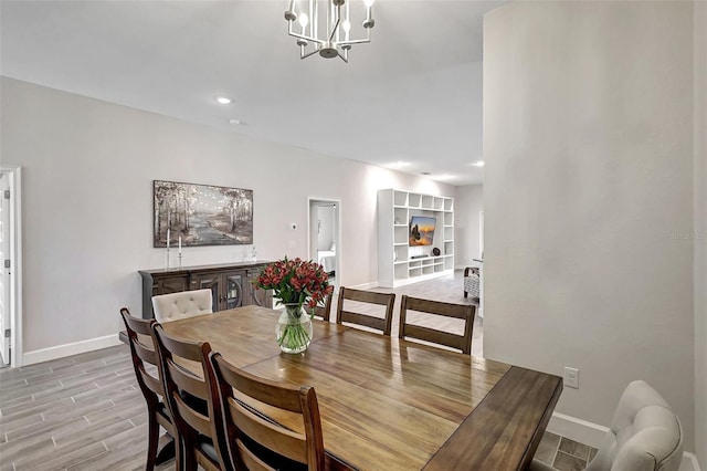 dining room with recessed lighting, baseboards, light wood-type flooring, and an inviting chandelier