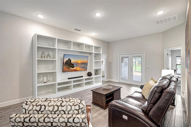 living room with wood finish floors, visible vents, and french doors