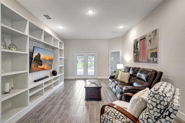 living room with wood finish floors, visible vents, baseboards, and french doors