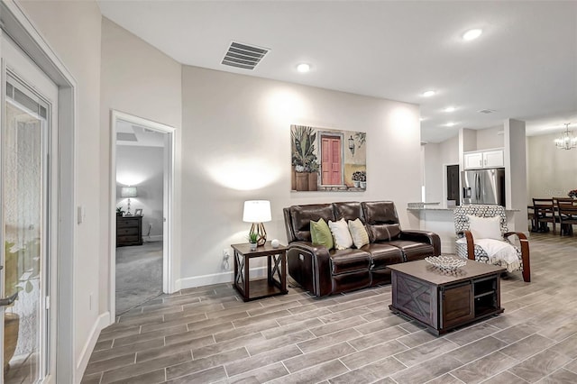 living room featuring light hardwood / wood-style floors and a notable chandelier