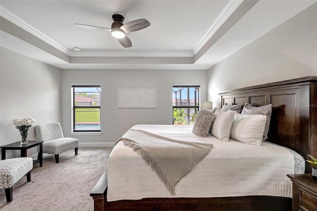 bedroom featuring a tray ceiling, multiple windows, ceiling fan, and carpet floors